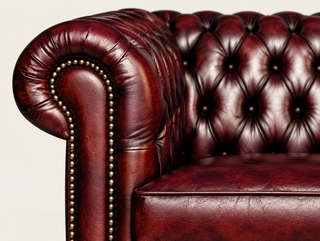 Antique Rosso Chesterfield Tudor Low Back Armchair, close-up of the rolled arm, deep buttoning and brass studs