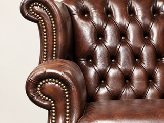Antique Brown Chesterfield Tudor High Back Armchair, close-up of the wing, rolled arm and deep buttoning