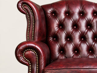 Antique Rosso Chesterfield Tudor High Back Armchair, close-up of the wing, rolled arm and deep buttoning